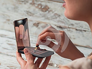 Close up photo of woman lips with lipstick in hand. Makeup artist. Creative make up artist.