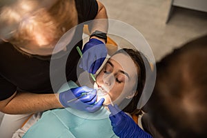 Close-up photo of woman with open mouth with mirror for dental equipment.