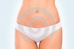 Close-up photo of woman`s belly with the drawing arrows. Stomach health concept.