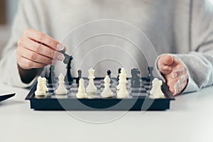 Close-up photo of a woman`s hands making a move in a game of chess