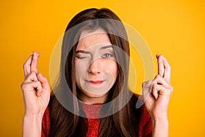 Close up photo of worried troubled desparate girlfriend with fingers crossed blinking with one eye under pressure hoping