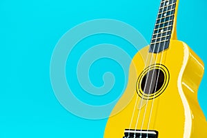 Close-up photo of yellow ukulele with copy space