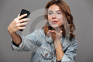 Close-up photo of young attractive woman sending air kiss while