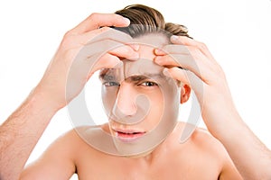 Close up photo of young man looking for acnes on his face