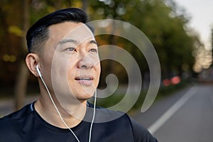 A close-up photo of a young serious man Asian male sportsman standing on the road in the middle of the street in
