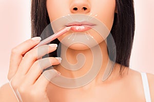 Close-up photo of young woman doing maquillage with lip`s liner, close up photo with arrows