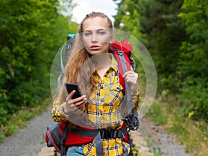 Close-up photo of a young woman, who lost in forest. She using mobile GPS map.
