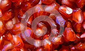 This is a close-up photograph of pomegranate seeds, showing their vibrant red color and texture.