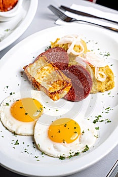 Close-up photograph of a traditional Dominican Mangu breakfast, featuring fried eggs