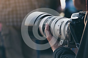 Close up photographer holding telephoto lens