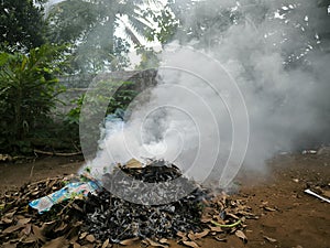 Close up photos burn dry fallen leaves that produce thick smoke.