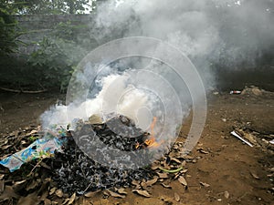 Close up photos burn dry fallen leaves that produce thick smoke.