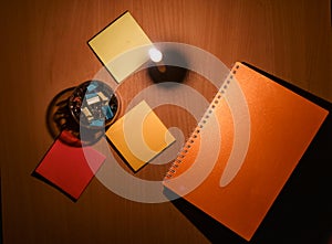 Close-up photos of notebooks and paper clips placed on the table with orange light from candles