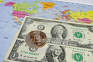 Close up physical bitcoin coin with US dollars and world map.