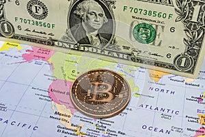 Close up physical bitcoin coin with US dollars and world map.