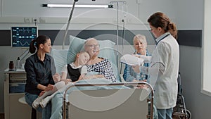 Close up of physician consulting ill patient with family in visit