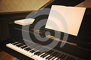 Close up of Piano keys with blank music sheet, toned image processed with filtered vintage effect