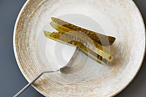 a close up of a pickle on a plate with tomatoes