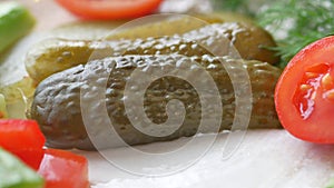 a close up of a pickle on a plate with tomatoes