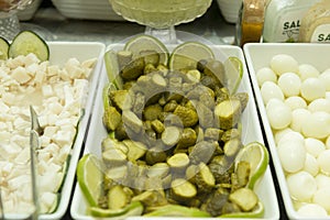 Close-up of pickled cucumber chopped into pieces in a white ceramic bowl