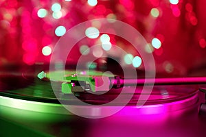 Close-up of a pickup head on a vinyl record, color illumination, analogue retro music concept, audio experience, relaxation,