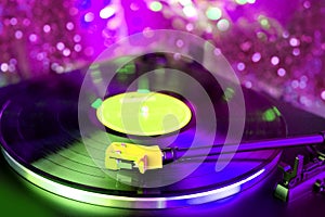 Close-up of a pickup head on a vinyl record, color illumination, analogue retro music concept, audio experience, relaxation,