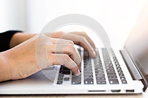 A close-up picture of a business man typing on a laptop keyboard .