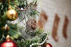 Close up picture of christmas ornaments on green artificial Xmas tree. Red and golden baubles, silver bead garland and christmas