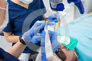 Close-up picture of dental instruments: drill and needle for root canal treatment and pulpitis in hand at the dentist in