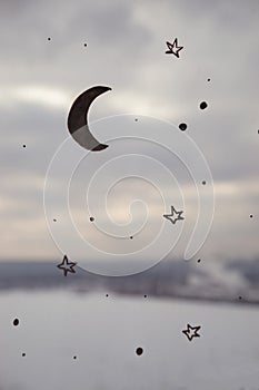 Close up picture of drawing moon and stars on the window