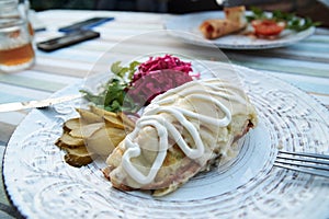 Close-up picture of fancy restaurant dish on white plate served on table. Young man having dinner lunch in cafe. Delicious