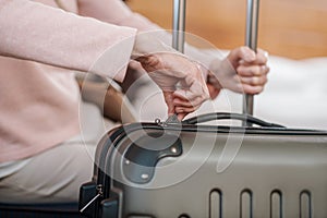 Close up picture of female hand zipping suitcase