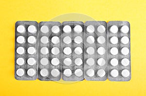 Close-up picture of a few packages of painkillers. Antibiotics in packs. Pills, drugs on a yellow background.