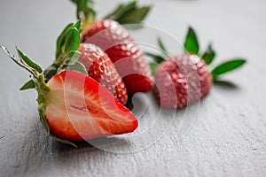 Close up picture of fresh red strawberries lying on a black stone table