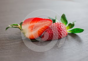 Close up picture of fresh red strawberries lying on a black stone table