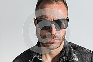 Close up picture of handsome bearded man wearing sunglasses