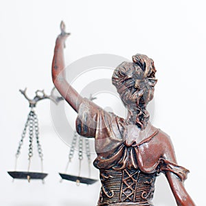 Close up picture of lady justice or themis goddess standing back holding scales blindfold on white background