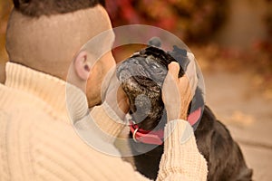 A close up picture of a man looking at his dog with tenderness