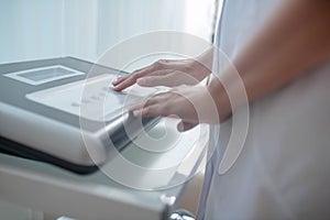 Close up picture of medical equipment and human hands touching it