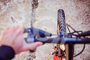 Mountain bike tyres outside, blurry handlebar, summer day, city mobility