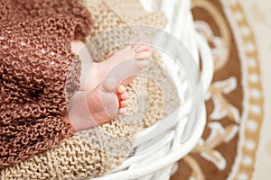 Close up picture of new born baby feet in knitted plaid