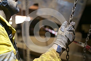 Close up picture of rigger hand commencing pulling a heavy duty chains block lifting load photo