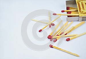 Close up picture of some flammable red fire matches scattered beside a small match box