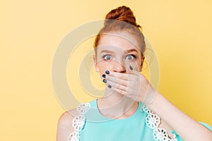 Close up picture of suprised ginger woman covering her mouth