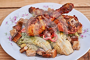 Close up picture of tasty and juicy sweet and spicy grilled chicken drumsticks on fresh lettuce salad.