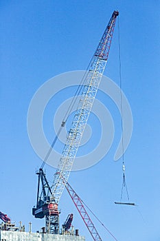 Close up picture of tower crane on top of highrise building construction site in Dubai