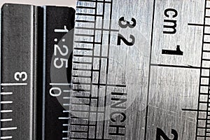 Close-up picture of two steel rulers showing the size difference between inches and centimeters.