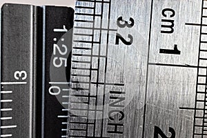 Close-up picture of two steel rulers showing the size difference between inches and centimeters. photo