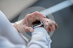 Close up picture of a womans hands touching a smartwatch