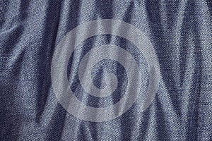 Close up picture of wrinkly blue jeans fabric background.